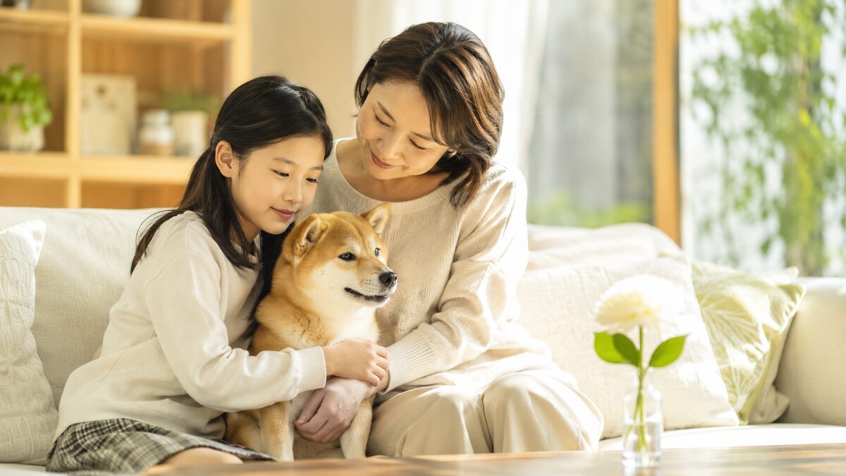 リビングで柴犬に寄り添う母娘